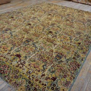 Intricately patterned rug in gold, maroon, blue, and pink covers worn wooden plank flooring.