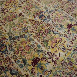 Detailed cream rug with a dense all-over pattern of colorful florals, birds, and vases.