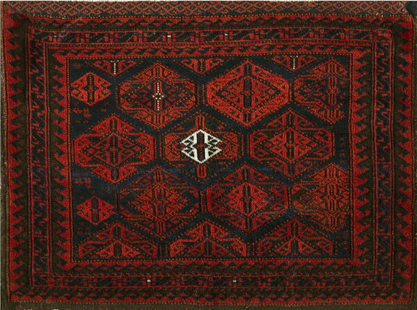 Square rug with dark red hexagonal patterns against a deep indigo field and geometric borders.