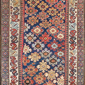 Long runner rug with a navy blue field featuring geometric motifs and multi-colored traditional borders.