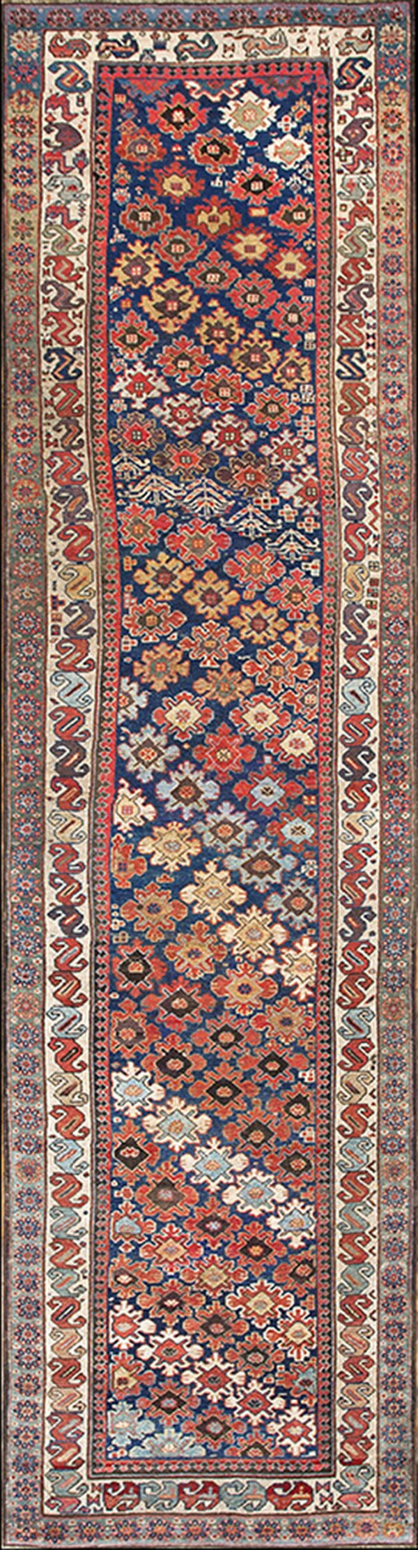 Long runner rug with a navy blue field featuring geometric motifs and multi-colored traditional borders.