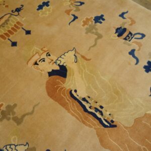 A beige rug features a detailed navy blue and rust figural pattern, partially visible on wooden flooring.