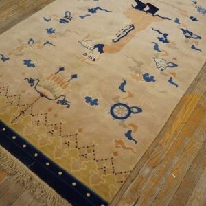 A plush tan rug with blue, peach, and yellow stylized motifs lies on distressed wide-plank wood flooring.