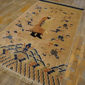 Camel field rug featuring navy, rust, and beige figurative and geometric wave patterns on worn wood floors.