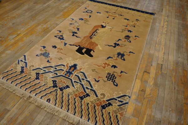 Camel field rug featuring navy, rust, and beige figurative and geometric wave patterns on worn wood floors.