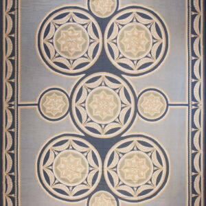 Light blue rug with navy and cream borders framing interlocking circular medallions and eight-pointed stars.
