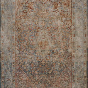 Distressed rug with an ornate floral pattern in muted blue, rust, and tan tones.