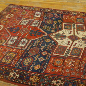 Geometric rug with rust, navy, and cream medallions lies diagonally on a honey-toned wood floor.