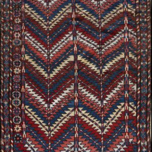 Red, navy blue, and cream geometric rug with vertical columns of dense zigzag motifs and a complex border.