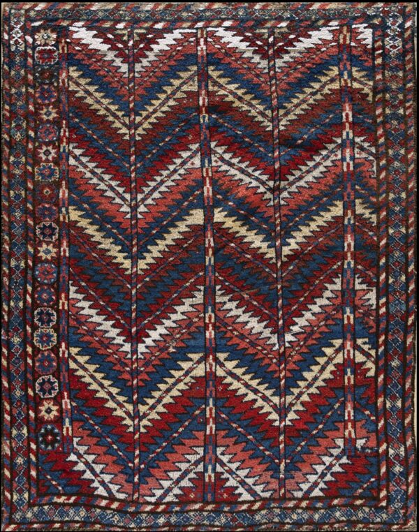 Red, navy blue, and cream geometric rug with vertical columns of dense zigzag motifs and a complex border.