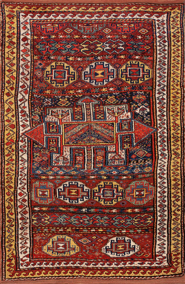 Red geometric rug with a central medallion and complex borders in navy blue, cream, and mustard yellow.