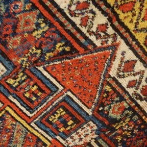 Highly textured pile rug featuring geometric patterns and bands of red, blue, yellow, and cream.