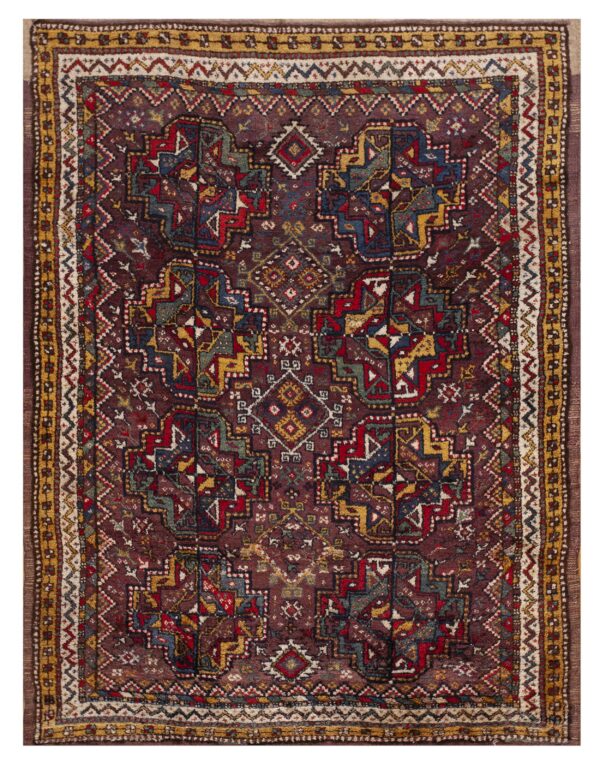 Deeply saturated geometric rug featuring a dark red field with complex patterns in gold, blue, and cream.