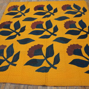 Yellow flatweave rug with repeating dark teal and maroon botanical patterns on rustic wood planks.