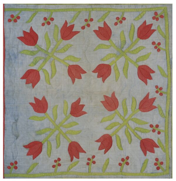 Pale blue appliquéd textile with large red tulip and green floral motifs in a symmetrical design.