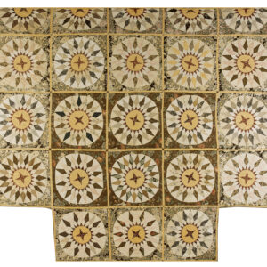 Muted patchwork rug featuring repeating circular starburst designs in beige, brown, and mustard yellow.