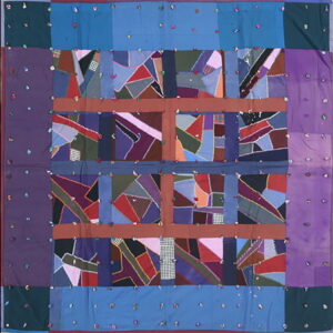 Colorful textile featuring abstract patchwork squares divided by brown stripes and solid purple and blue borders.