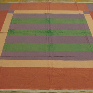 Flat rug with striped green and purple center, surrounded by tan and embossed rust borders on wood flooring.