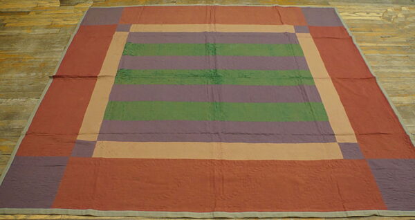 Flat rug with striped green and purple center, surrounded by tan and embossed rust borders on wood flooring.