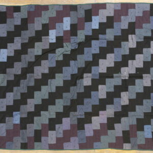 Flat textile featuring a staggered diagonal pattern in black and shades of dusty blue, gray, and mauve.