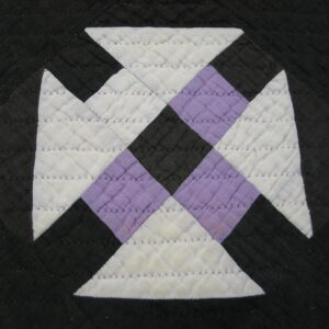 Geometric quilted pattern in black, white, and lavender fabric showing stitched diamond texture.