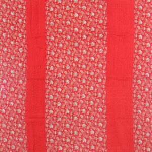 Red textile featuring vertical quilted solid stripes alternating with dense multicolored paisley floral patterns.