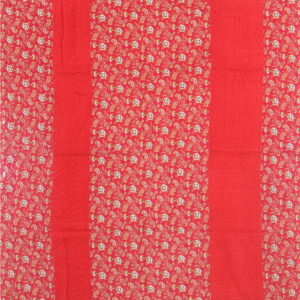 Red textile with alternating stripes: solid quilted red and patterned red featuring paisley and flowers.