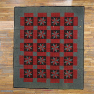 Red and black star quilt block motifs alternate with red checkered squares on a dark gray rug.