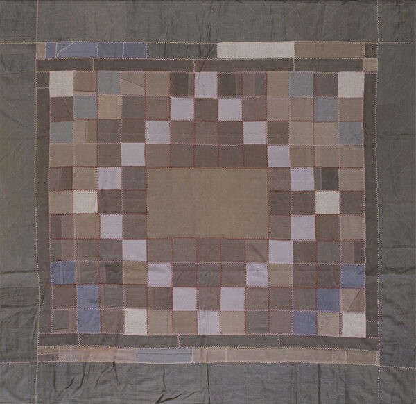 Patchwork rug featuring a taupe center surrounded by a border of checkered neutral and blue squares.