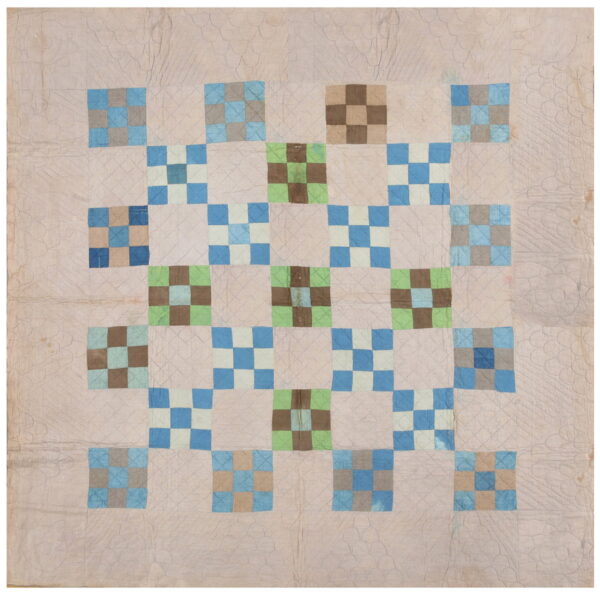 Flat quilted textile with a geometric grid pattern in pale beige, blue, green, and brown squares.