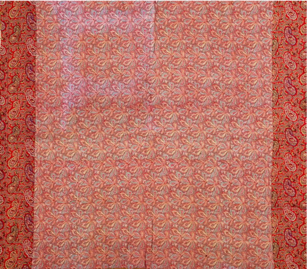 Intricate red rug with large repeating floral motifs bordered by dense traditional red paisley patterns.