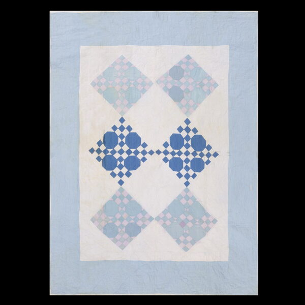 Patchwork textile featuring light blue, pink, and deep blue octagon and diamond repeating patterns on white.