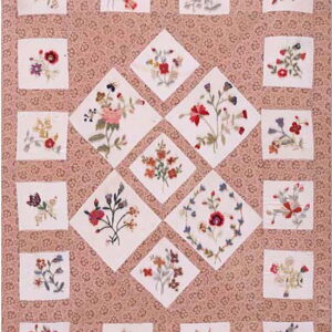 A rose-patterned textile features white square and diamond patches with colorful embroidered floral bouquets.