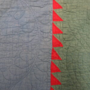 Stitched blue and muted green fabric with a bright red vertical border of sawtooth triangles.