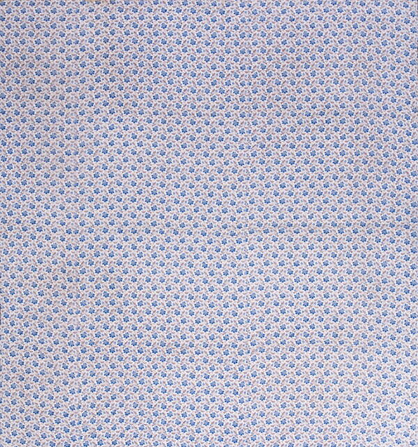 Flat woven rug featuring a micro-floral pattern in blue and muted tan on a light background.