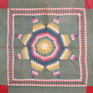 Flat green textile featuring a large multicolored star motif and a red and white sawtooth border.