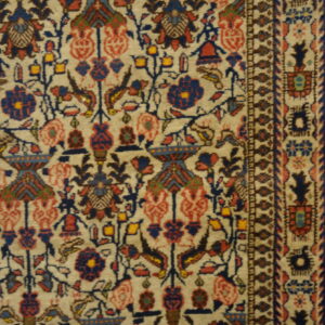 Detailed, short-pile rug in beige, blue, and red featuring intricate floral and geometric patterns bordering light wood.