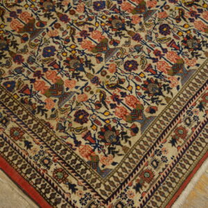 Cream rug featuring red and blue stylized floral patterns and a detailed border on distressed wooden planks.