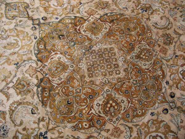 Low-pile rug displays a detailed medallion and dense traditional pattern in cream, gold, rust, and navy.