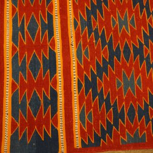 Geometric flat-weave rug featuring a dense red and blue jagged pattern and striped orange and navy borders.