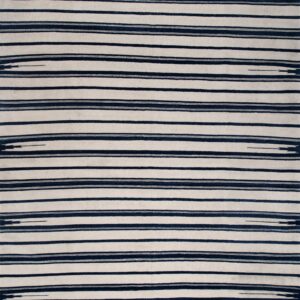 A wide white and dark blue striped rug with fringe ends is displayed on distressed wooden flooring.