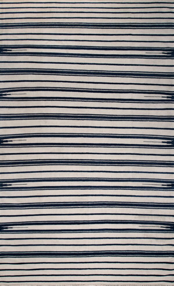 A wide white and dark blue striped rug with fringe ends is displayed on distressed wooden flooring.