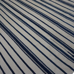 Flatweave rug featuring wide alternating stripes of off-white and dark navy blue.