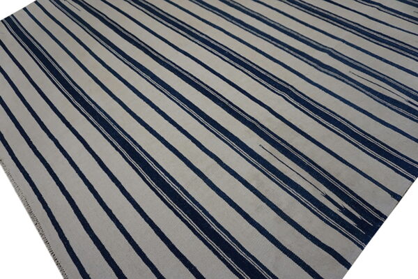 Flatweave rug featuring wide alternating stripes of off-white and dark navy blue.