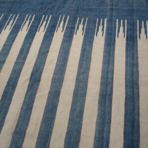 Blue and cream striped low-pile rug with a detailed geometric motif topping the stripes near the edge.