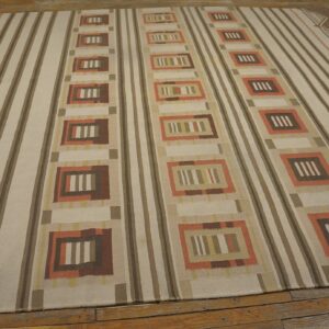 Cream and brown striped flatweave rug with repeating geometric columns and zigzag borders on wood flooring.