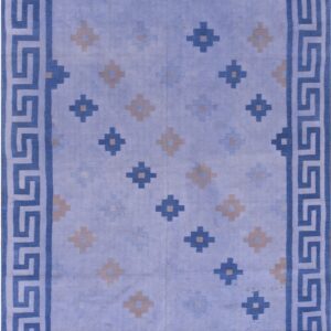 Flatwoven blue rug featuring a Greek key border and scattered beige and blue repeating motifs.