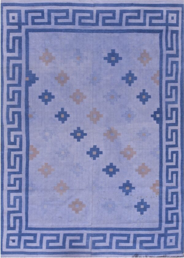 Flatwoven blue rug featuring a greek key border and scattered beige and blue repeating motifs.