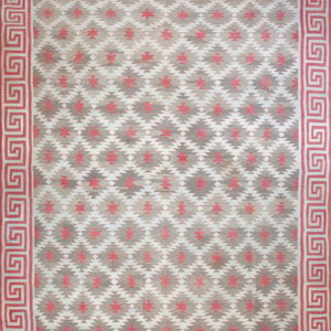 Flatweave rug with pink, grey, and white southwestern patterns and a coral Greek key border.