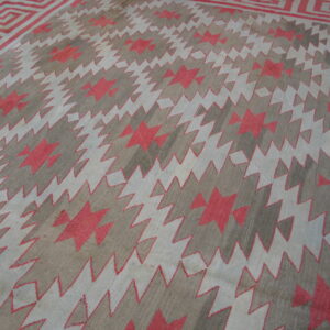 Geometric rug featuring a zigzag field and Greek key border in gray, light blue, and coral red.